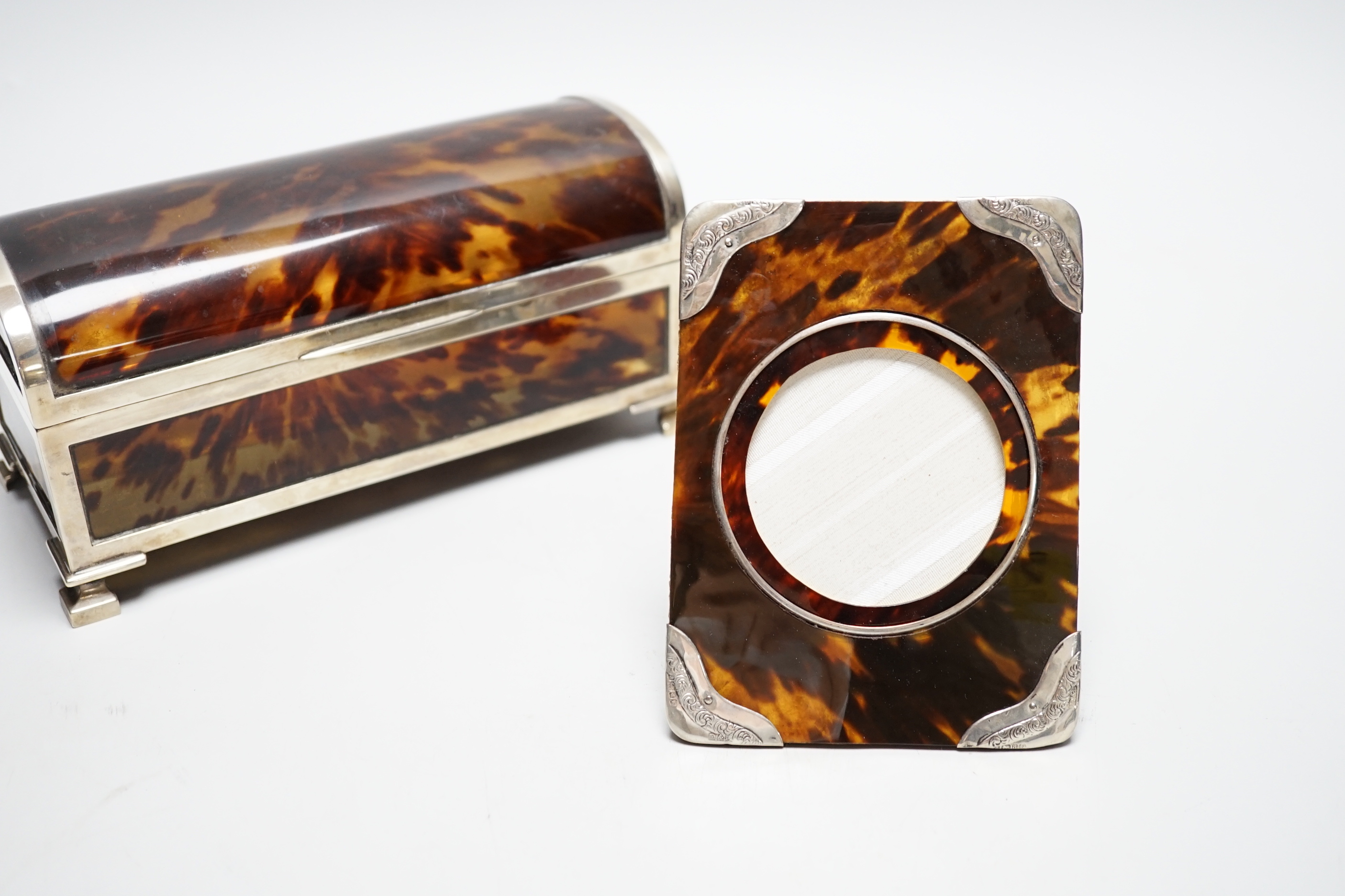 A George V silver mounted tortoiseshell domed top jewellery casket (a.f.) J.Batson & Sons, London, 1916, retailed by Asprey, London, 19.6cm, together with a small Edwardian silver mounted tortoiseshell photograph frame.